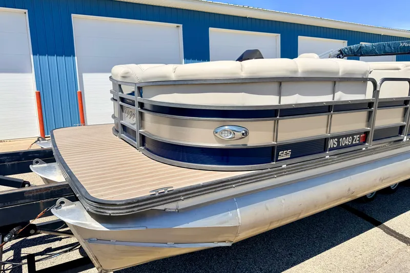 Slide: The Image of 2015 Manitou 25 SES BENCH pontoon boat parked near blue building. - 8