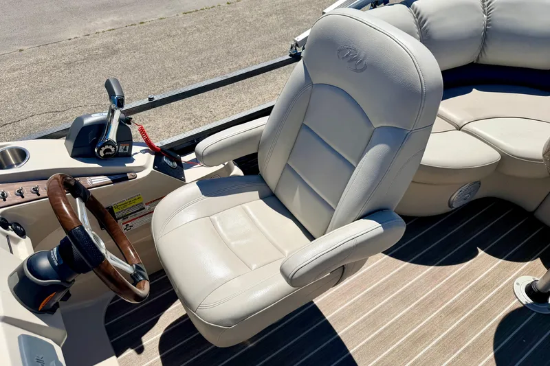 Slide: The Image of 2015 Manitou 25 SES BENCH boat interior with steering wheel and plush seating. - 53