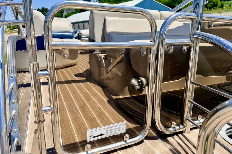 Slide: The Image of 2015 Manitou 25 SES BENCH boat interior with sleek metal railings and comfortable seating. - 24