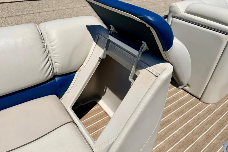 Slide: The Image of 2015 Manitou 25 SES BENCH with open storage compartment on a boat deck. - 63