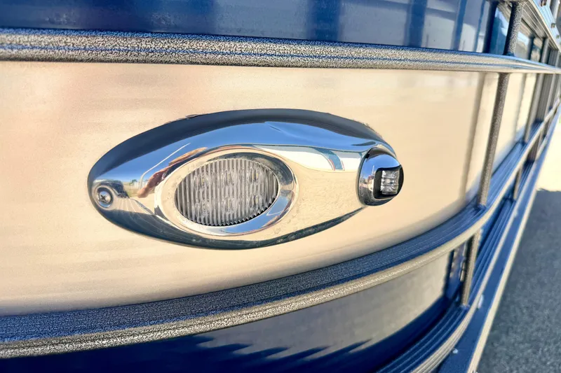 Slide: The Image of Close-up of a 2015 Manitou 25 SES BENCH boat's sleek exterior light. - 93