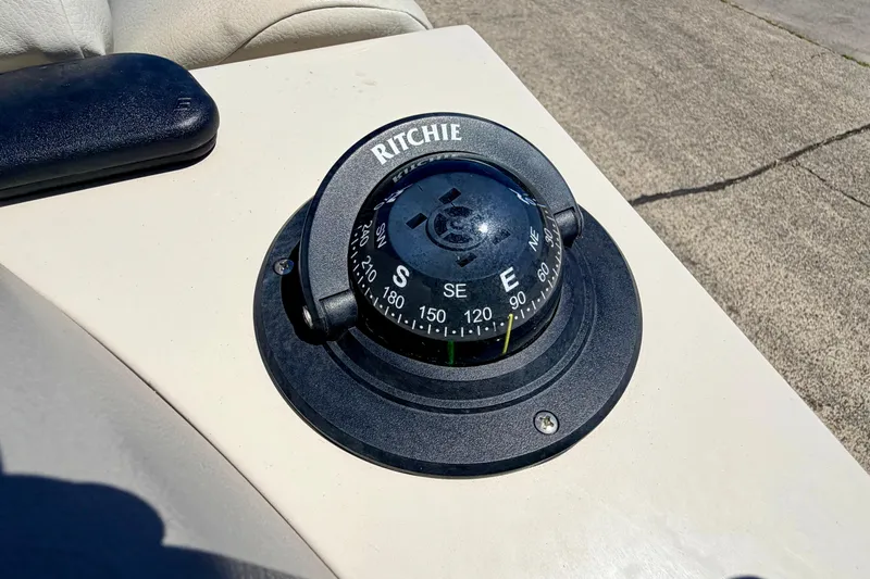 Slide: The Image of Ritchie compass on 2015 Manitou 25 SES BENCH boat dashboard, showing southeast direction. - 87