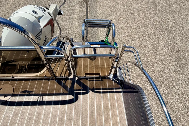 Slide: The Image of 2015 Manitou 25 SES BENCH boat with outboard motor and stainless steel railings. - 76