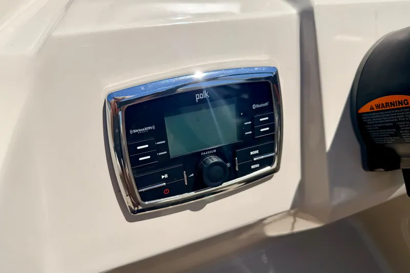 Slide: The Image of Polk audio system on 2015 Manitou 25 SES BENCH boat dashboard, featuring Bluetooth and SiriusXM. - 49