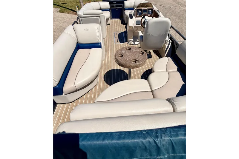 Slide: The Image of 2015 Manitou 25 SES BENCH pontoon boat interior with beige seating and wood-style flooring. - 80