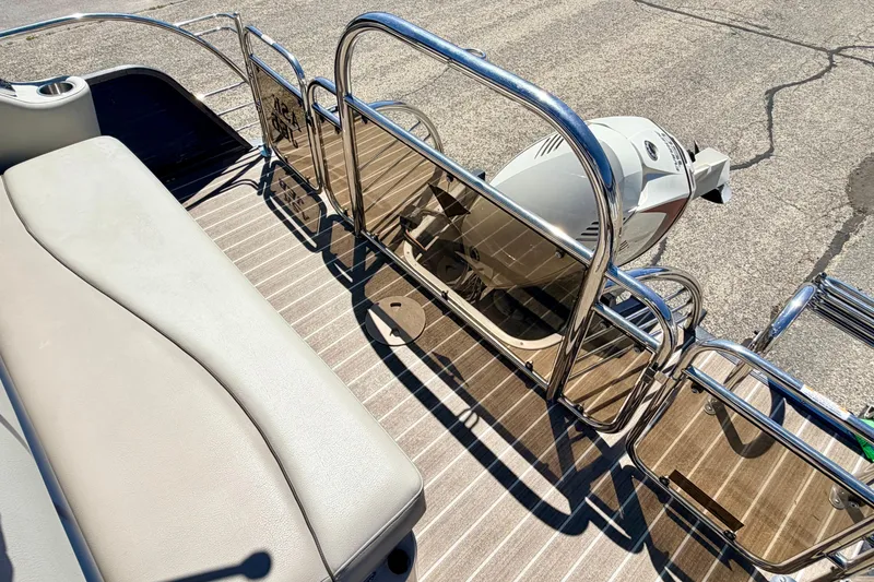 Slide: The Image of 2015 Manitou 25 SES BENCH boat with sleek seating and polished metal railings. - 75
