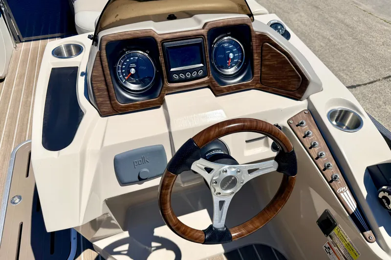 Slide: The Image of 2015 Manitou 25 SES BENCH dashboard with wood accents and steering wheel. - 46