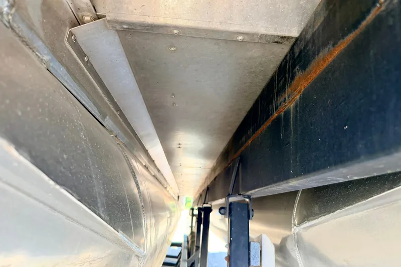 Slide: The Image of Underneath view of a 2015 Manitou 25 SES BENCH pontoon boat, showcasing structural details. - 95
