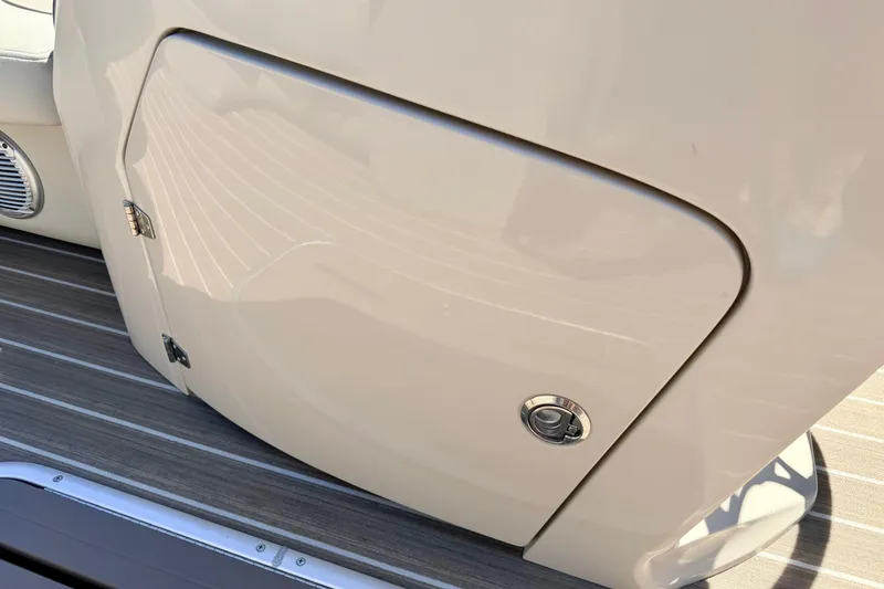 Slide: The Image of 2015 Manitou 25 SES BENCH boat compartment with beige finish and metal latch. - 42