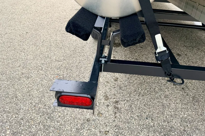 Slide: The Image of Trailer hitch and light of a 2015 Manitou 25 SES BENCH on pavement. - 101