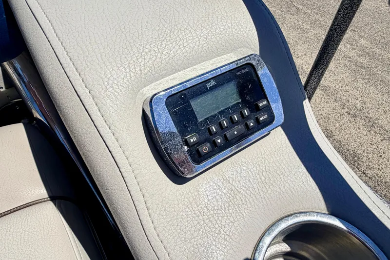 Slide: The Image of Polk audio system on 2015 Manitou 25 SES BENCH boat, with cup holder nearby. - 73