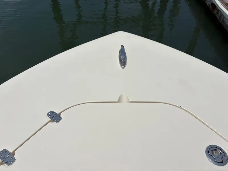 Slide: The Image of The bow of a 2019 Scout 215 XSF boat, featuring an anchor fitting and calm water. - 30