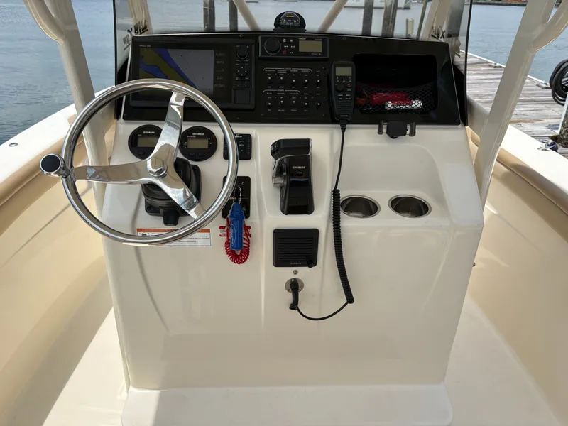 Slide: The Image of The image shows the helm of a 2019 Scout 215 XSF boat with various instruments. - 18