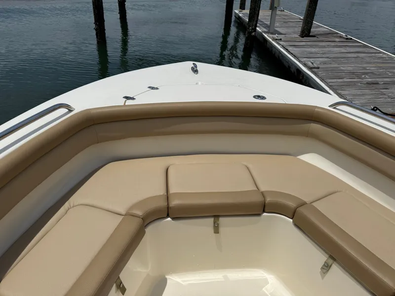 Slide: The Image of The image shows the bow of a Scout 215 XSF boat with beige cushions and a dock in the background. - 28