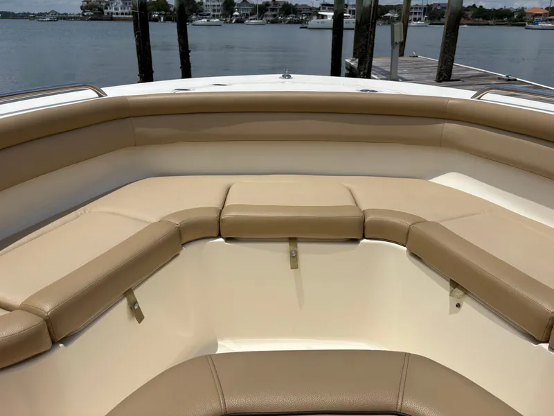 Slide: The Image of The image shows the bow area of a 2019 Scout 215 XSF boat with beige cushions. - 29