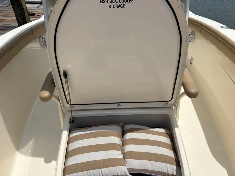 Slide: The Image of A 2019 Scout 215 XSF boat with open storage containing striped cushions. - 37