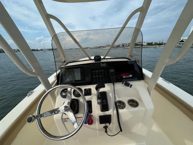 Slide: The Image of The image shows the helm of a 2019 Scout 215 XSF boat on the water. - 12