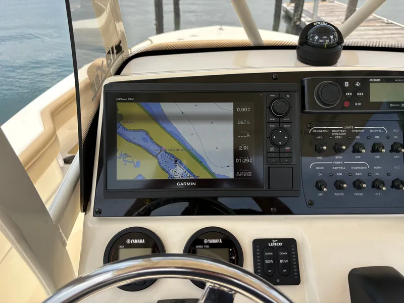 Slide: The Image of The image shows the helm of a Scout 215 XSF boat with a Garmin navigation system. - 19
