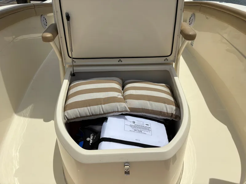 Slide: The Image of An open storage compartment on a boat with striped cushions and gear. - 36