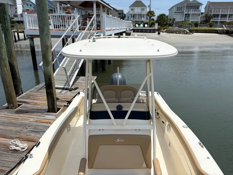 Slide: The Image of A 2019 Scout 215 XSF boat docked at a wooden pier. Beach houses are visible in the background. - 25