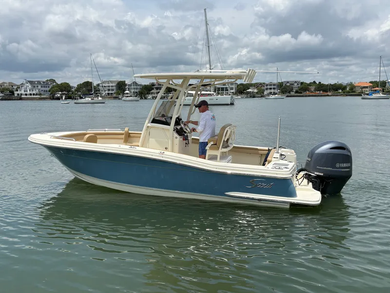 Slide: The Image of A 2019 Scout 215 XSF boat on calm water with a person on board. - 4