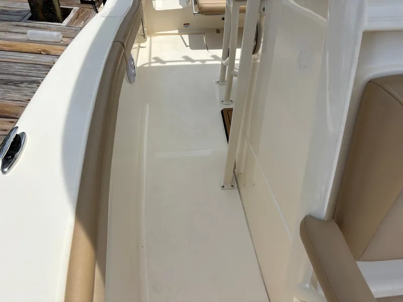 Slide: The Image of The image shows the deck of a Scout 215 XSF boat with beige upholstery. - 41