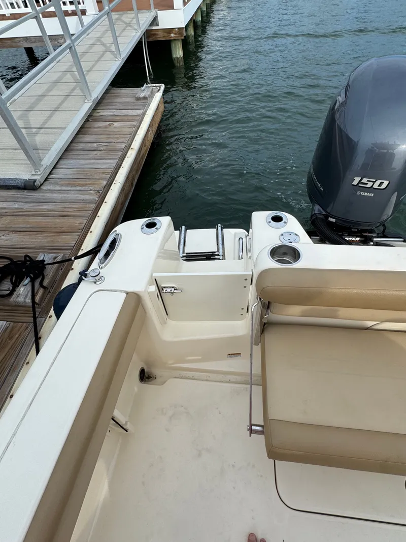 Slide: The Image of The image shows the stern of a 2019 Scout 215 XSF boat docked at a pier. - 48