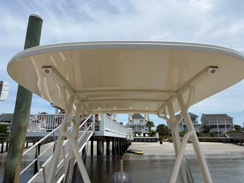 Slide: The Image of A Scout 215 XSF boat with a sturdy T-top, docked at a pier. - 44