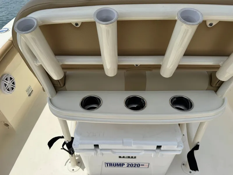Slide: The Image of The image shows the back of a boat seat with rod holders and a cooler. - 46