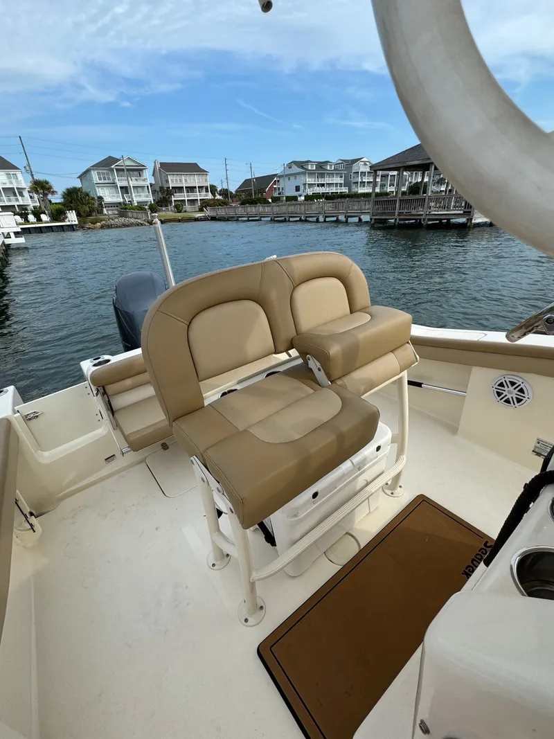 Slide: The Image of The image shows the cockpit of a 2019 Scout 215 XSF boat with beige seating. - 23