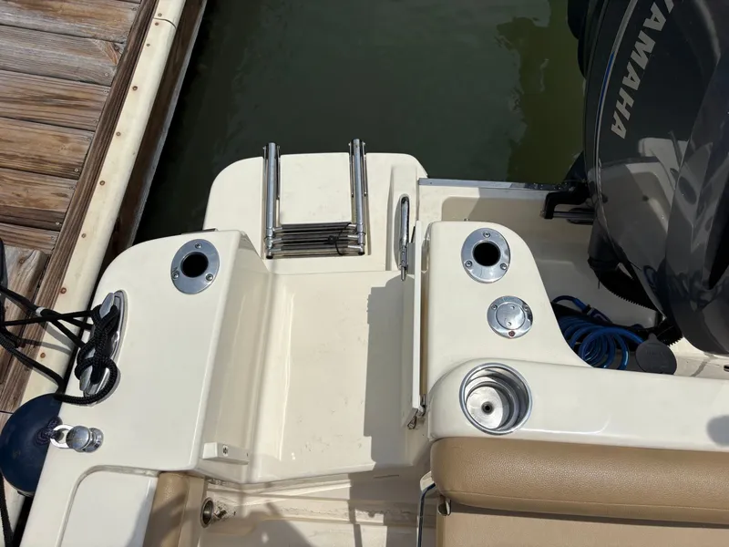 Slide: The Image of The image shows the stern of a 2019 Scout 215 XSF boat with a swim ladder and Yamaha engine. - 49