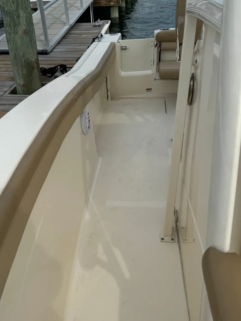 Slide: The Image of The image shows the deck of a 2019 Scout 215 XSF boat with beige upholstery. - 40