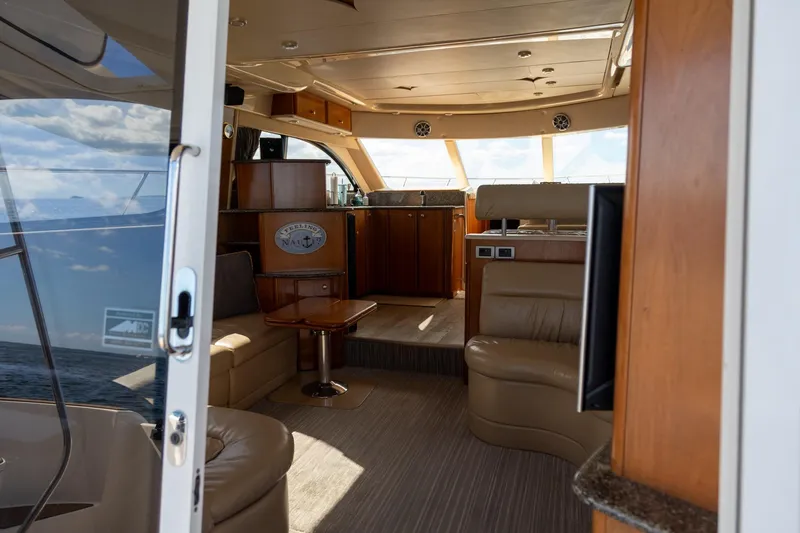 Slide: The Image of Interior of a 2004 Meridian 411 Sedan yacht, featuring luxurious seating and wooden cabinetry. - 15