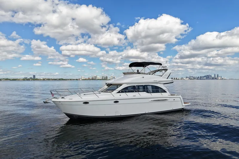 Slide: The Image of 2004 Meridian 411 Sedan yacht cruising on calm waters under a partly cloudy sky. - 1