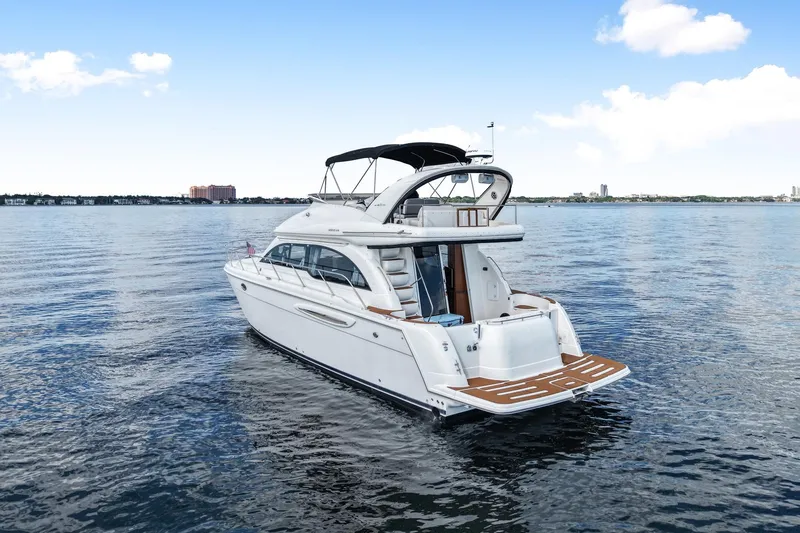 Slide: The Image of 2004 Meridian 411 Sedan yacht on calm water, showcasing sleek design and spacious deck. - 4