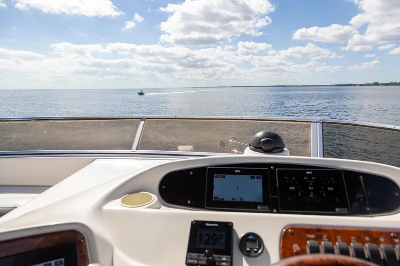 Slide: The Image of Helm view from 2004 Meridian 411 Sedan yacht, overlooking calm ocean waters. - 8