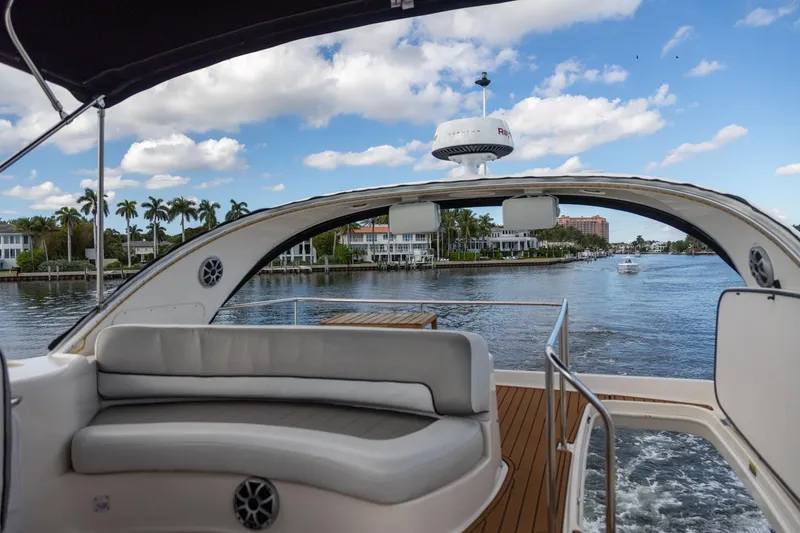 Slide: The Image of 2004 Meridian 411 Sedan yacht interior with waterfront view, featuring luxurious seating and scenic backdrop. - 12