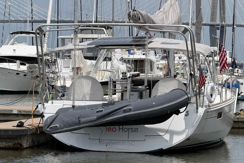 Slide: The Image of 2017 Beneteau Oceanis 45 sailboat docked, featuring solar panels and American flags. - 5