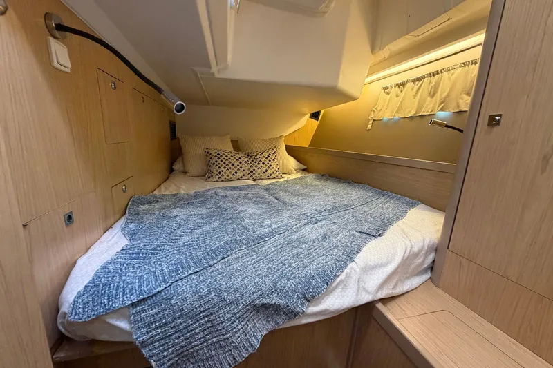Slide: The Image of Cozy cabin interior of 2017 Beneteau Oceanis 45 yacht with bed and wooden finish. - 45