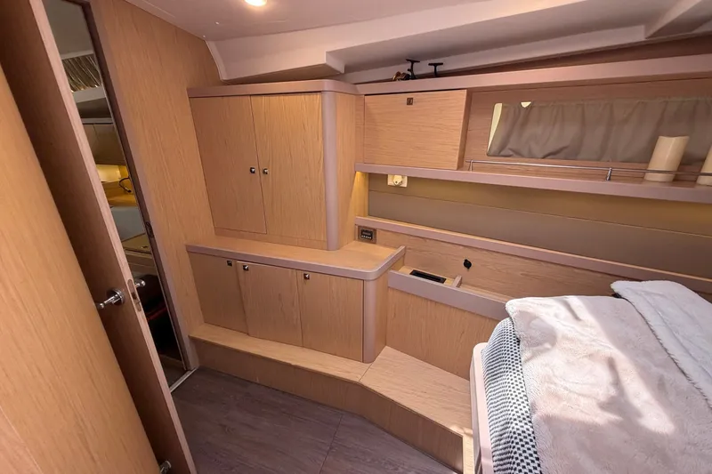 Slide: The Image of Interior of 2017 Beneteau Oceanis 45 yacht, featuring wooden cabinetry and cozy bedding. - 40