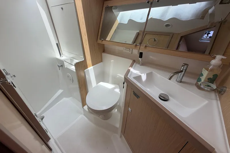 Slide: The Image of Modern bathroom interior of 2017 Beneteau Oceanis 45 yacht, featuring sink, toilet, and mirror. - 45