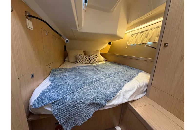 Slide: The Image of Cozy cabin interior of 2017 Beneteau Oceanis 45 yacht with bed and soft lighting. - 42
