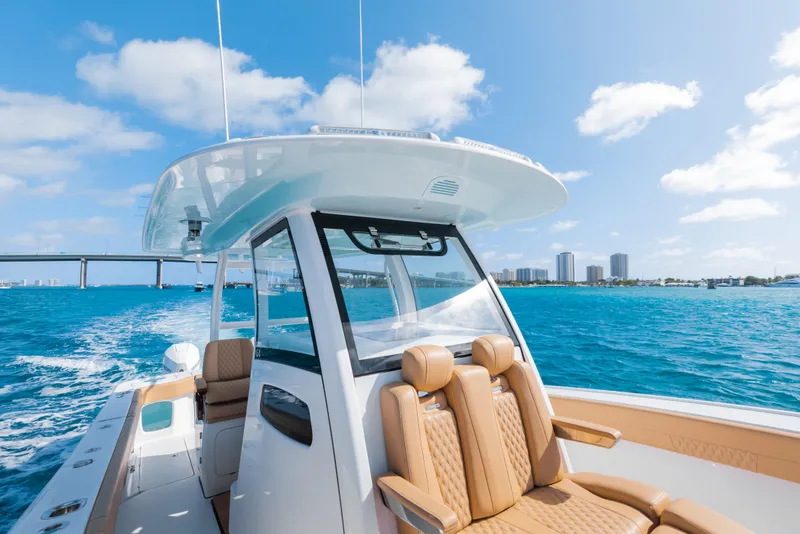 Slide: The Image of 2026 Phenom 34 Center Console boat cruising on blue ocean near city skyline. - 21