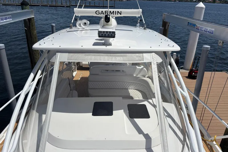 Slide: The Image of 2006 Intrepid 377 Walkaround boat docked, featuring Garmin equipment and spacious seating area. - 8
