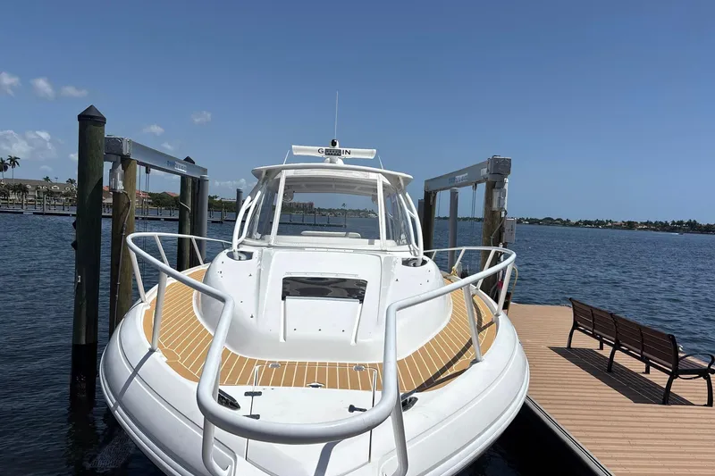 Slide: The Image of 2006 Intrepid 377 Walkaround boat docked by a serene waterfront. - 7