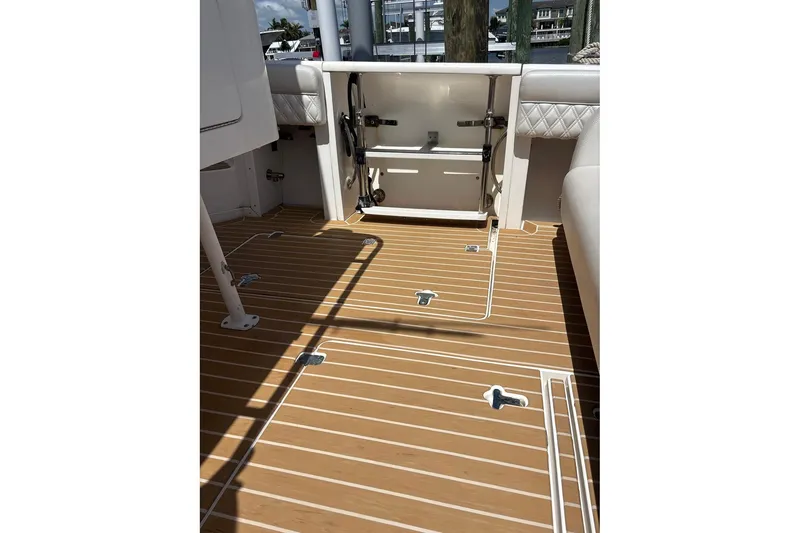 Slide: The Image of 2006 Intrepid 377 Walkaround boat deck with open storage compartment and teak flooring. - 13