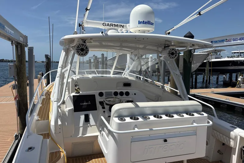 Slide: The Image of 2006 Intrepid 377 Walkaround boat docked, featuring Garmin and Intellian equipment. - 9
