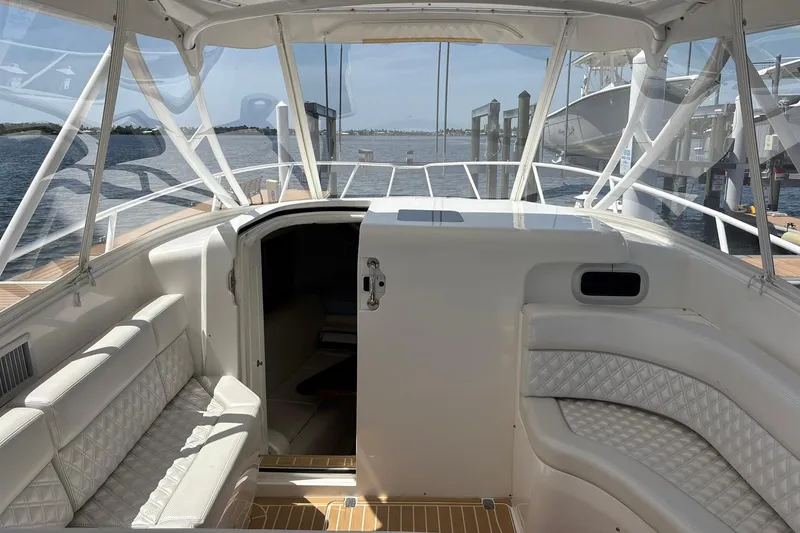 Slide: The Image of 2006 Intrepid 377 Walkaround boat interior with white seating and open cabin door. - 19