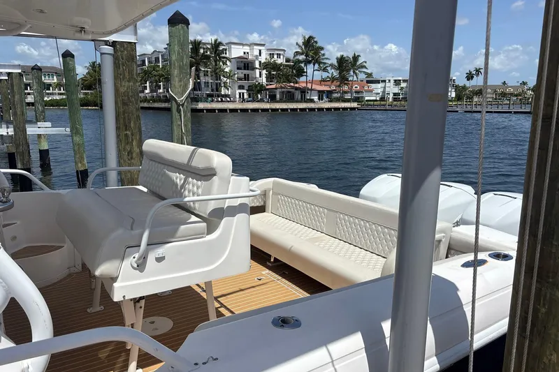 Slide: The Image of 2006 Intrepid 377 Walkaround boat docked, featuring spacious seating and scenic waterfront view. - 10