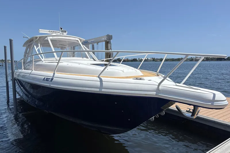 Slide: The Image of 2006 Intrepid 377 Walkaround boat docked by the water on a sunny day. - 6
